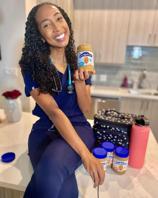 Victoria Humphrey assis au comptoir de la cuisine tenant une casserole de beurre d'arachide