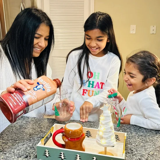 Lina Desai renversant un verre de lait avec du chocolat pour ses filles