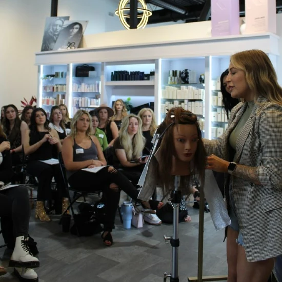 Kaylee smiley enseignant un cours de coiffure avec une tête muette