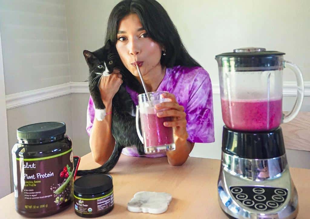 Lina Mayorga étreignant le chaton tout en buvant des protéines végétales Shake