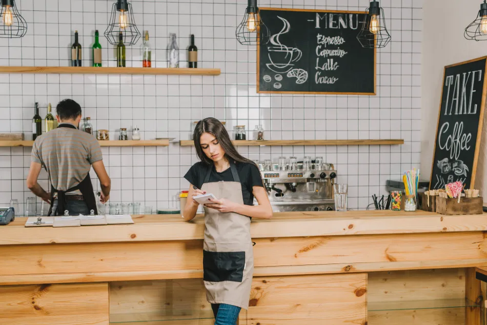 Barista du café au comptoir en vérifiant une commande client